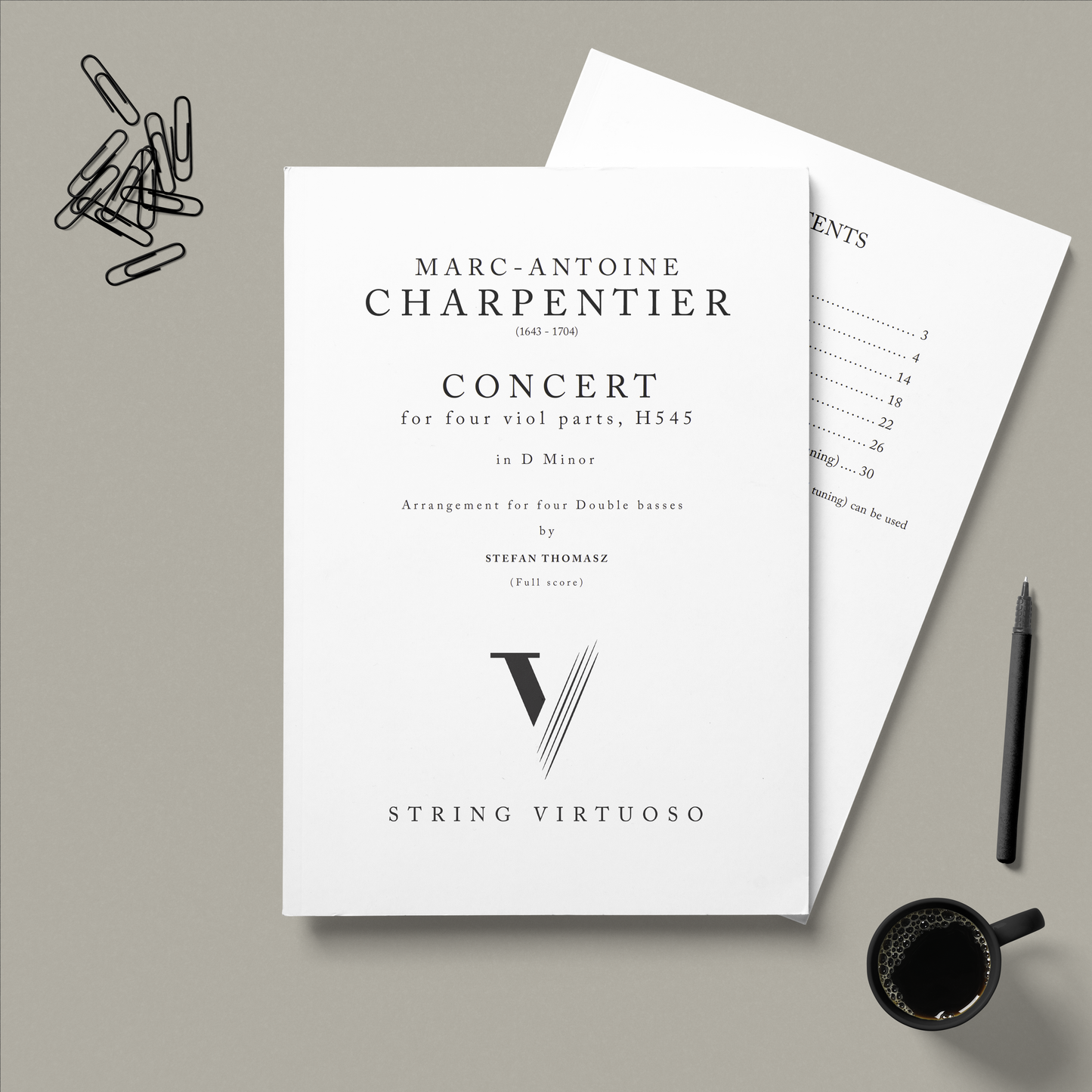Sheet music for Marc-Antoine Charpentier's 'Concert' for viol transcribed for double bass, by Stefan Thomasz with a pen and coffee cup on a grey background.