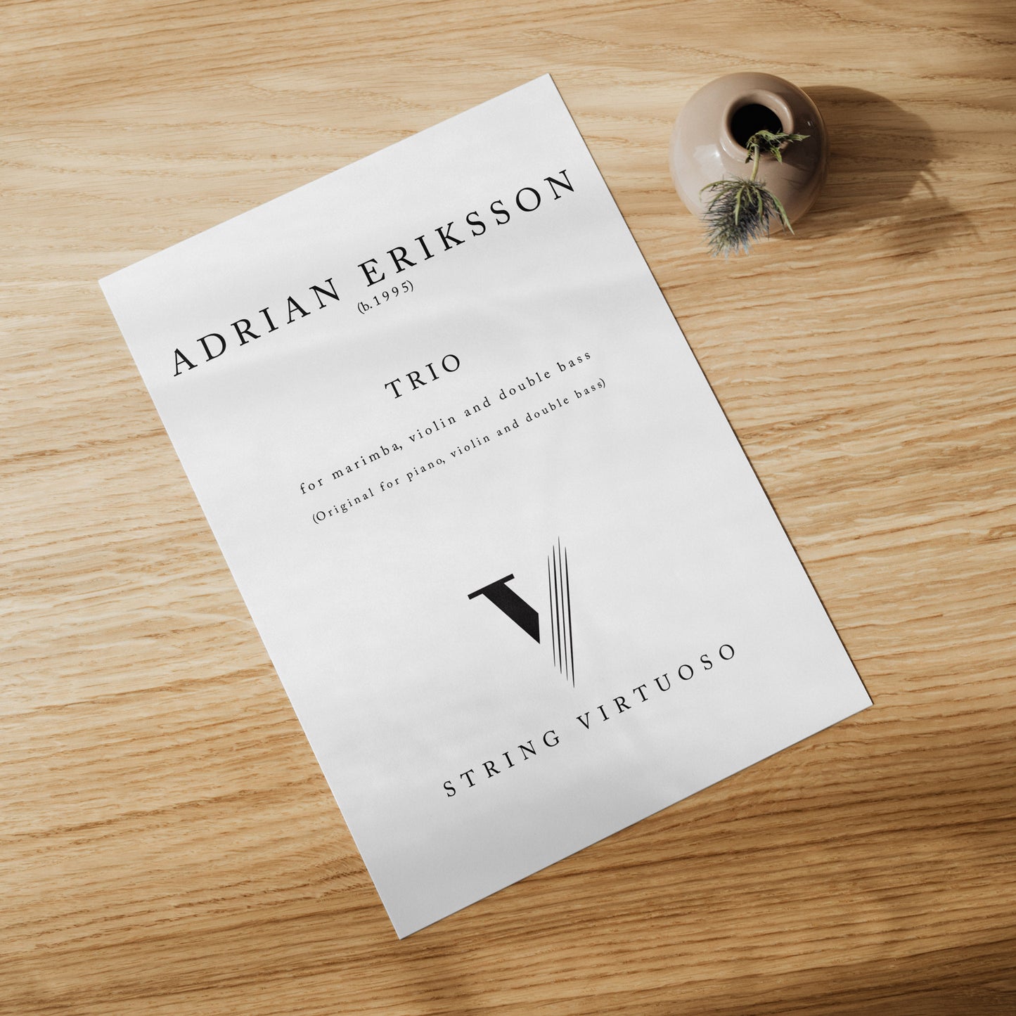 Sheet music of Adrian Eriksson's Trio for Marimba, Violin and Double Bass on a wooden table.
