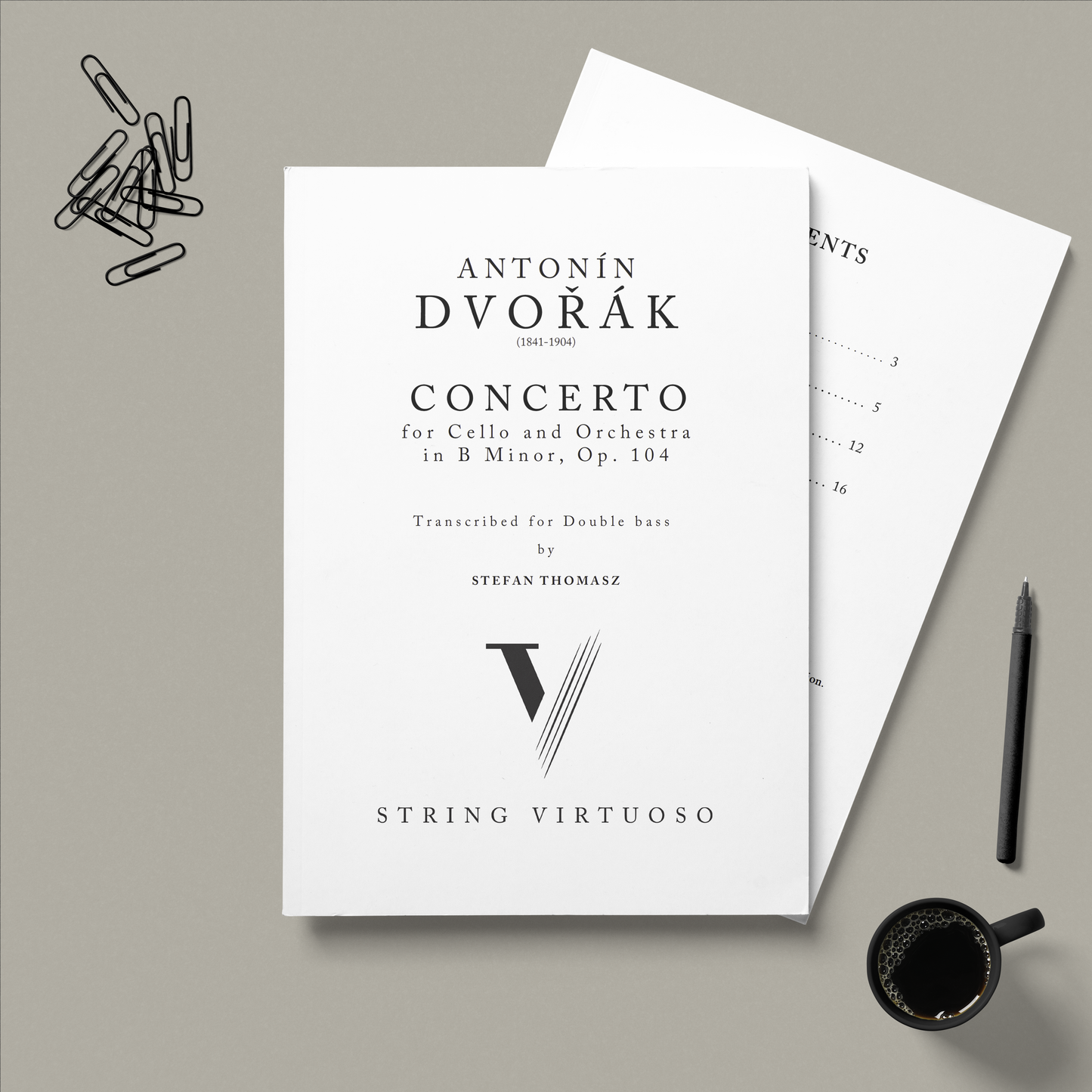 Sheet music for Antonin Dvorak's 'Concerto' transcribed for double bass with a pen and coffee cup on a grey background.