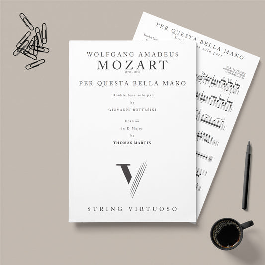 Sheet music for Wolfgang Amadeus Mozart's 'Per Questa Bella Mano' on a gray background with a pen and coffee cup.