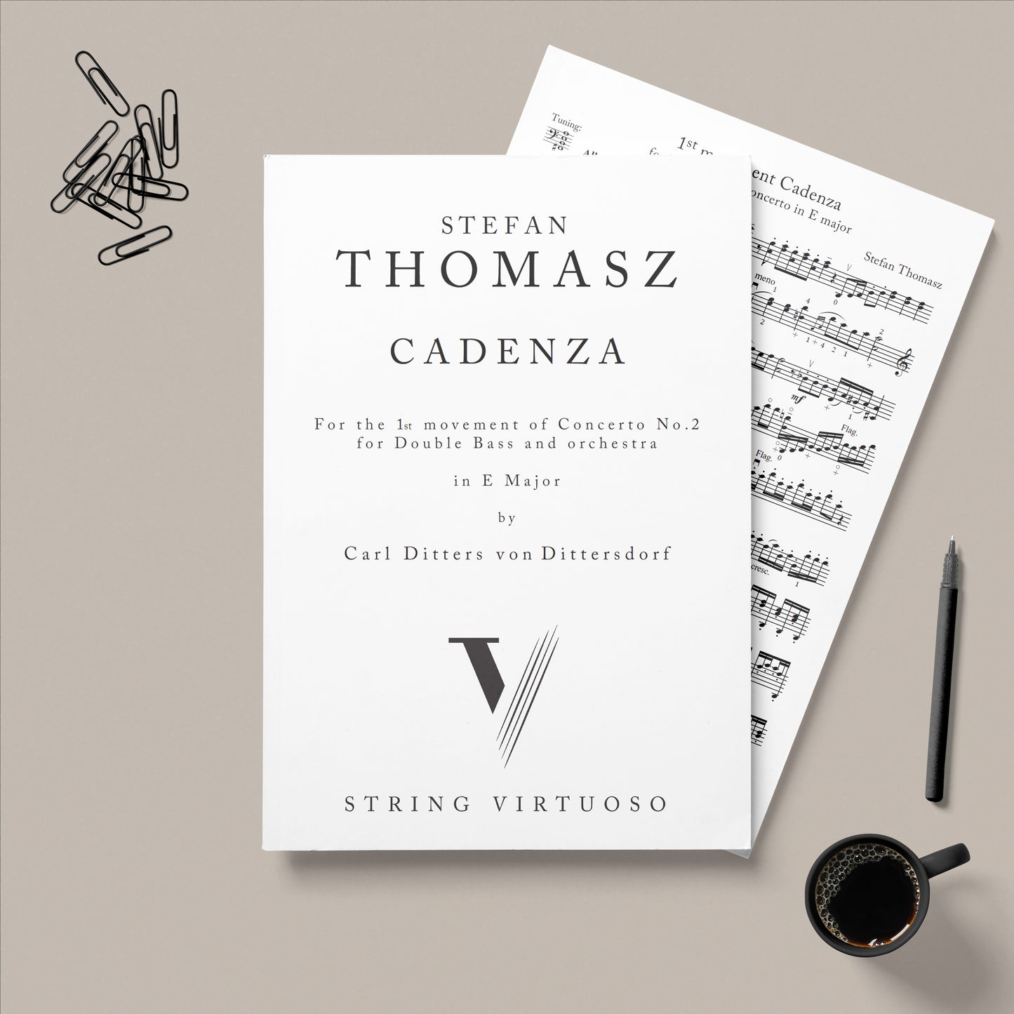 Sheet music for 'Cadenza' by Stefan Thomasz on a gray background with a pen and coffee cup.